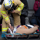 An injured passenger is assisted by an EMS worker as he lies on a gurney outside Atlantic Terminal after a Long Island Rail Road incident, Wednesday, Jan. 4, 2017, in the Brooklyn borough of New York. (AP Photo/Mark Lennihan)